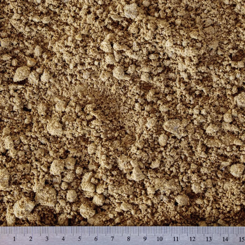 Detailní záběr na tříděný zásypový písek o velikosti částic od 0 do 4 mm, jemné a rovnoměrné granule.